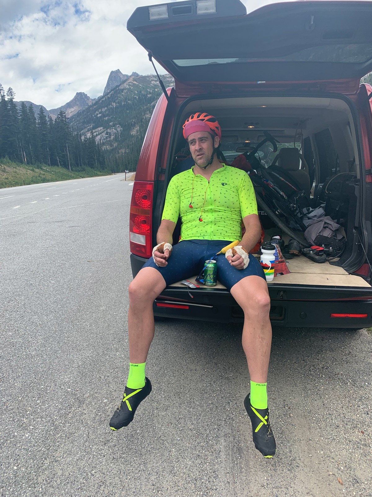 Rob Lea sitting on back of car, exhausted after ride.